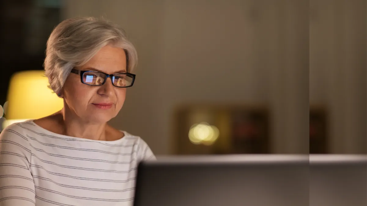 Senior woman researching Medicare on laptop